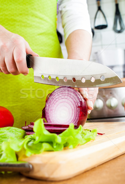 Stock photo: Woman's hands cutting bulb onion