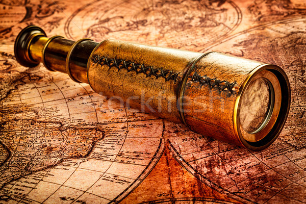 Vintage spyglass lies on an ancient world map Stock photo © cookelma