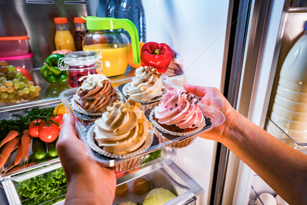 Woman takes the sweet cake from the open refrigerator Stock photo © cookelma