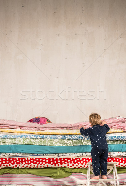 Stock photo: Child climbs on the bed - Princess and the Pea.