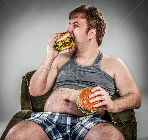 Vet man eten hamburger fauteuil stijl Stockfoto © cookelma