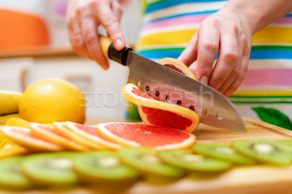 Women's hands Housewives cut with a knife fresh grapefruit on th Stock photo © cookelma
