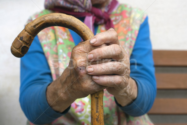 Stock photo: hands of an old woman with a cane