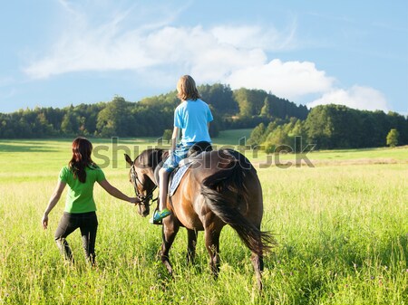 Horseback Riding Lessons - Woman Leading a Horse with a Boy in S Stock photo © courtyardpix