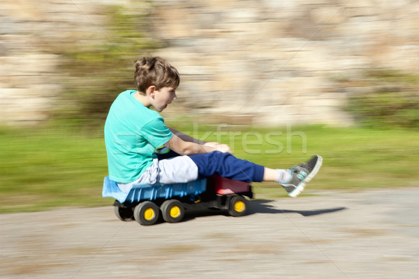 Boy Riding Downhill on Top of Toy Lorry Stock photo © courtyardpix