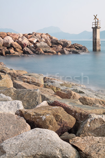 Lighthouse on a Rocky Breakwall: A small lighthouse warns of a r Stock photo © cozyta