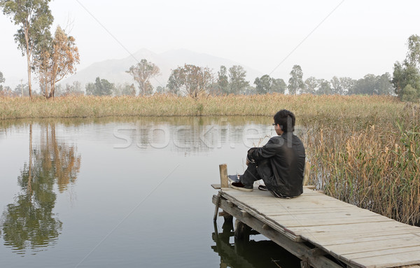 man sitting on a wooden pier Stock photo © cozyta