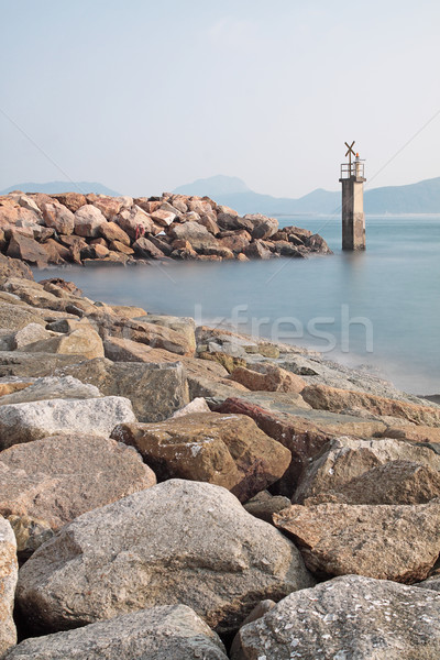 Lighthouse on a Rocky Breakwall: A small lighthouse warns of a r Stock photo © cozyta