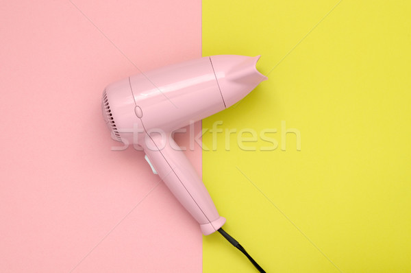 Pink hair dryer on pink and yellow background Stock photo © CsDeli