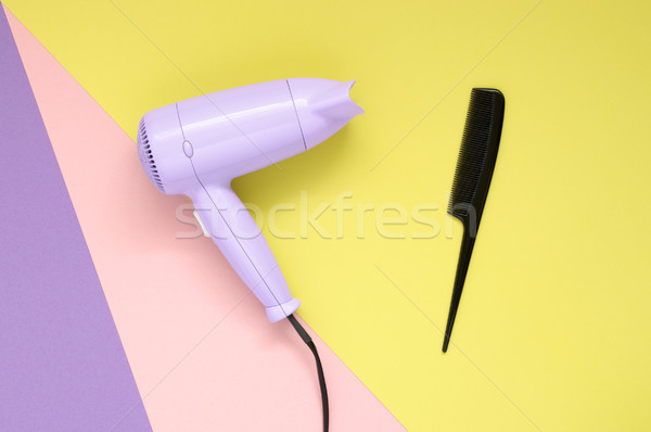 Hair dryer and comb on colorful paper background Stock photo © CsDeli