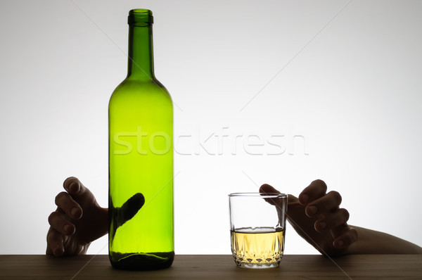 Hands reaching for a glass and a bottle Stock photo © CsDeli