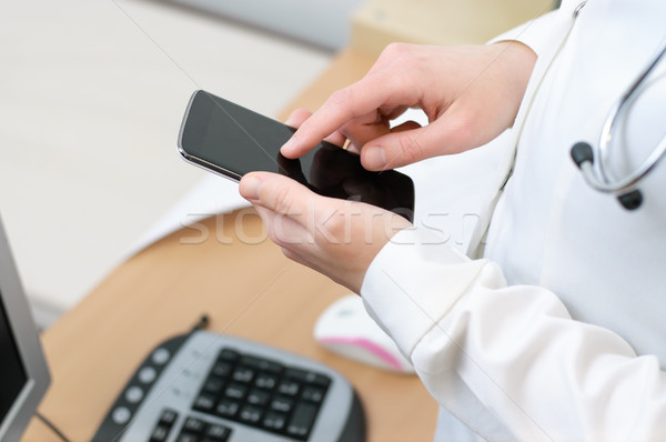 Női orvos sms chat okostelefon orvosi iroda Stock fotó © CsDeli