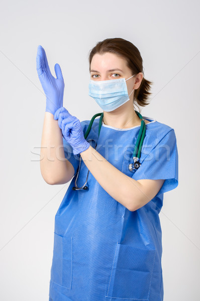 Doctor putting on blue surgical gloves Stock photo © CsDeli