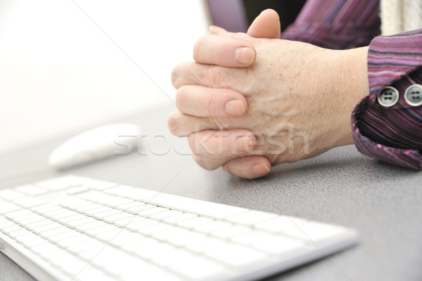 Hands of an old female typing on the keyboard, isolated on white, close-up. Stock photo © d13