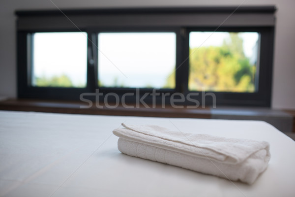 Clean white towel on the bed in hotel room Stock photo © d13