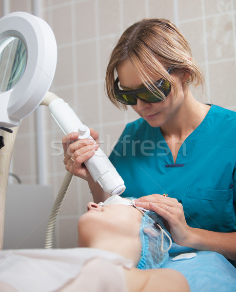Cosmetician providing facial treatment with a laser Stock photo © d13