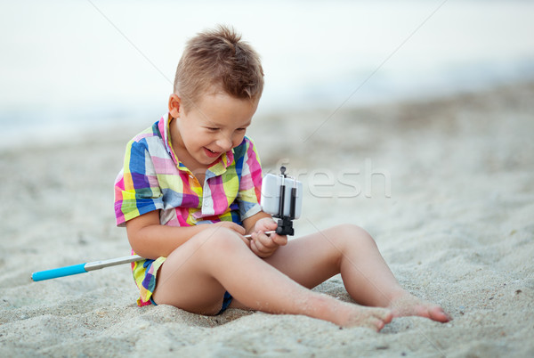 Happy boy with selfie stick and cell at the seaside Stock photo © d13