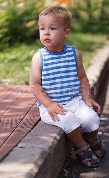 Cute boy sitting on the curb Stock photo © d13
