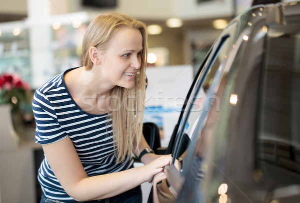 Woman admiring a car at an auto show Stock photo © d13