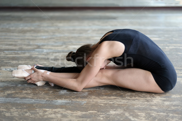Ballet dancer stretching out sitting on the floor Stock photo © d13
