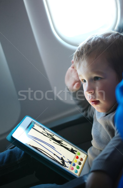 Little boy drawing on a tablet in an airplane Stock photo © d13