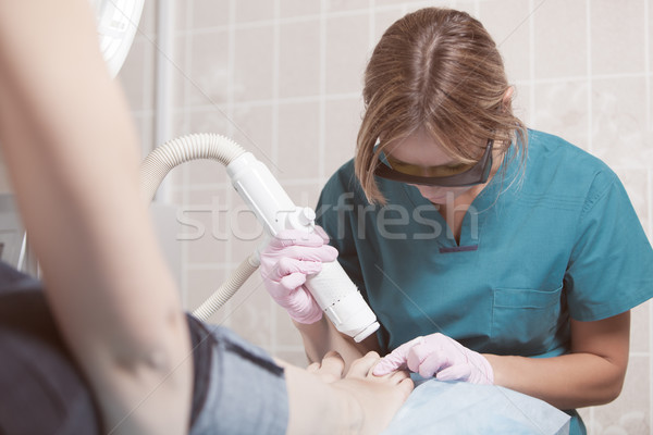Female cosmetician doing foot therapy using laser Stock photo © d13