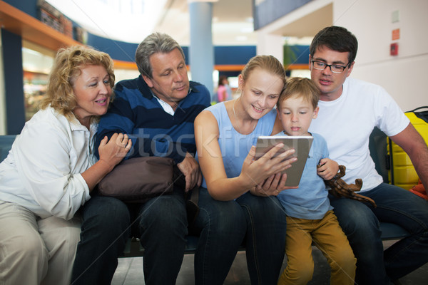 Big family entertaining with touch pad at the airport Stock photo © d13