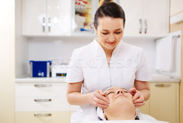 Professional beautician during the seance of facial massage Stock photo © d13