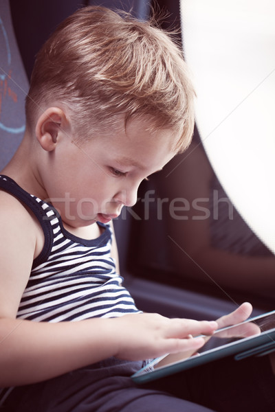 Little child using touch pad while traveling by bus Stock photo © d13