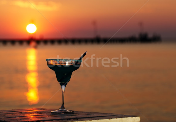 Tropical cocktail overlooking a sunset ocean Stock photo © d13