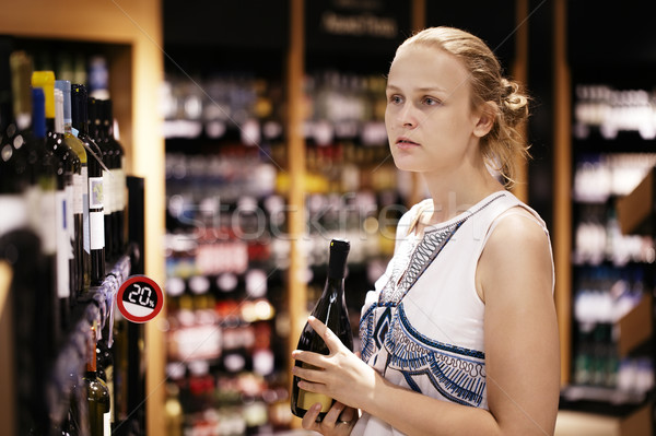 Woman shopping for alcohol in a bottle store Stock photo © d13