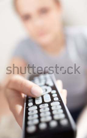 Young woman with remote watching TV. Stock photo © d13