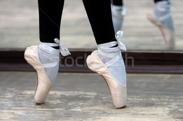 Stock photo: Close up view to ballerinas legs in pointes on wooden floor