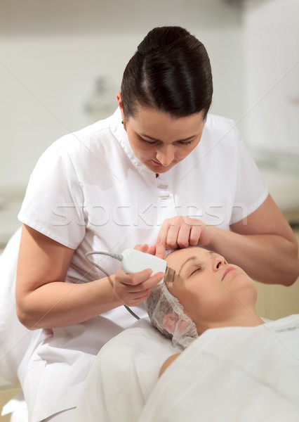 Cosmetician providing ultrasonic facial cleaning Stock photo © d13
