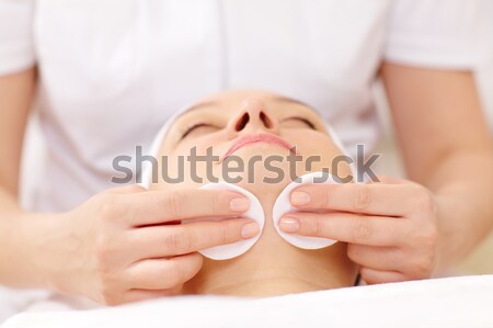 Cosmetician cleaning face using cotton pads Stock photo © d13