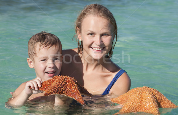 Mother and son in sea holding starfish Stock photo © d13