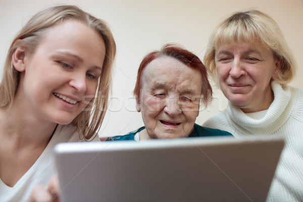 Stock photo: Three women using a smart tablet