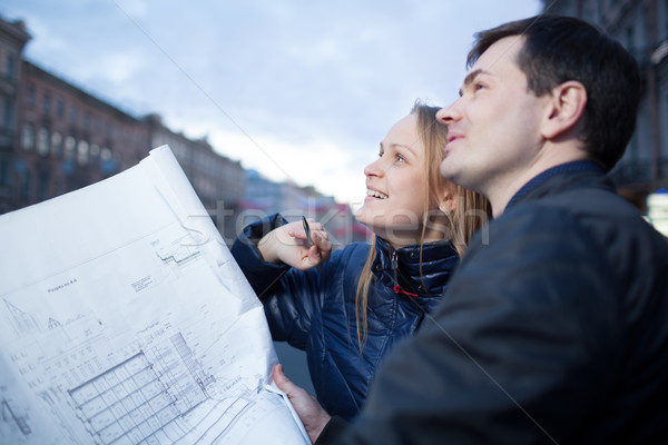 Couple holding blueprints admiring building Stock photo © d13