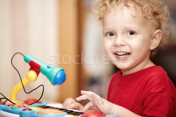 Adorable little boy playing with a toy microphone Stock photo © d13