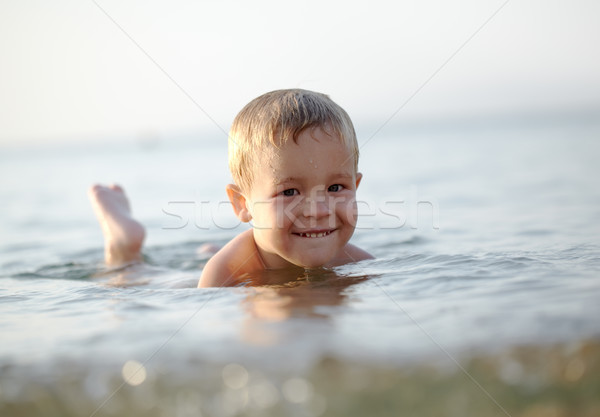 Sorridere piccolo ragazzo mare giù poco profondo Foto d'archivio © d13