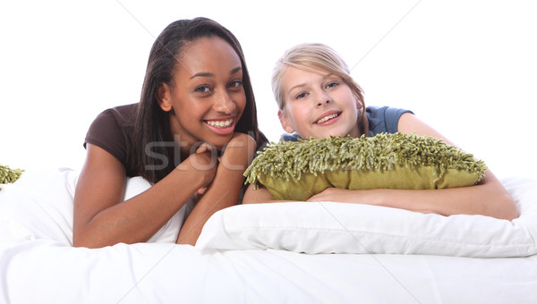 Black and white teenage girl friends lying on bed Stock photo © darrinhenry
