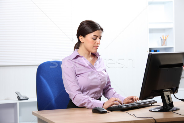 Beautiful woman typing at computer in office Stock photo © darrinhenry