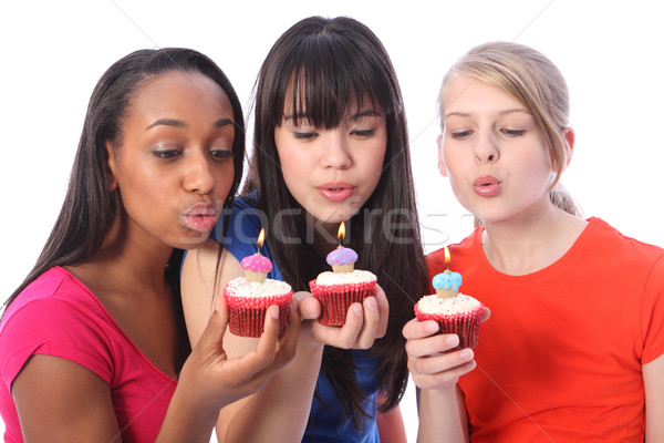 Teenage girl friends blowing out birthday candles Stock photo © darrinhenry