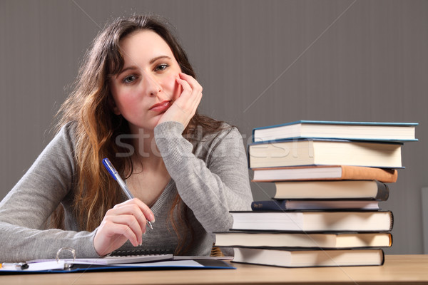 Tired student girl sitting to desk doing homework Stock photo © darrinhenry