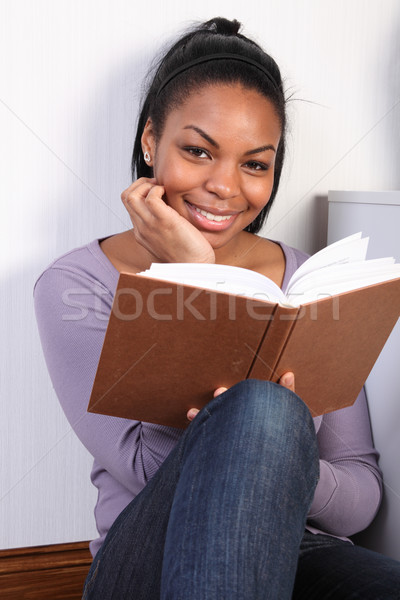 Beautiful happy african girl reading a book Stock photo © darrinhenry