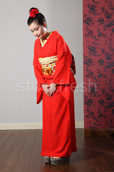 Oriental model in red Japanese kimono bowing Stock photo © darrinhenry