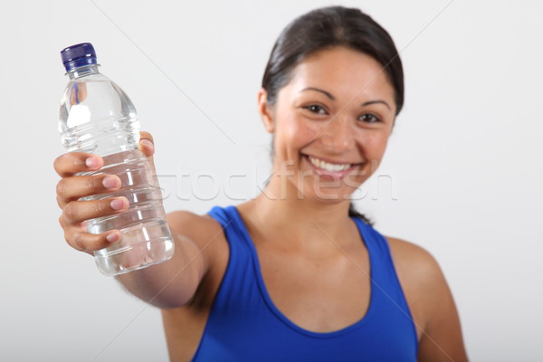 Bottled water held by beautiful smiling young woman Stock photo © darrinhenry