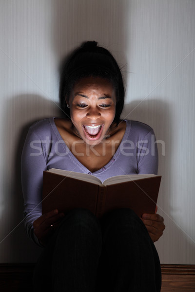 Young girl screams reading a spooky story book Stock photo © darrinhenry