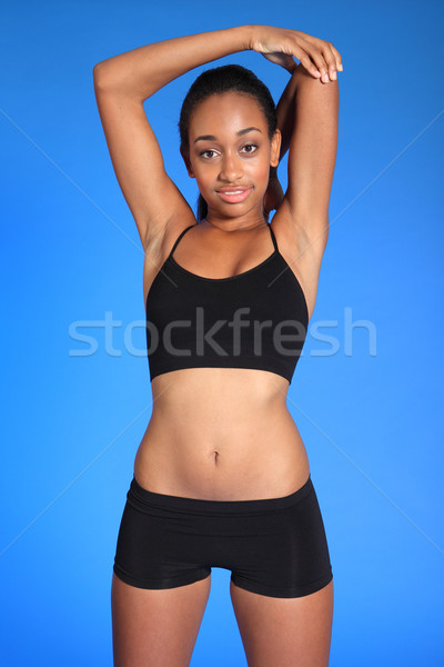 Fit body of African woman doing shoulder stretch Stock photo © darrinhenry