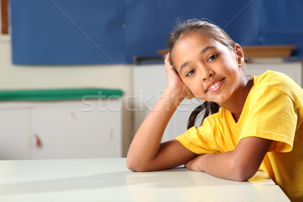School girl 10 relaxed while sitting at her classroom desk Stock photo © darrinhenry
